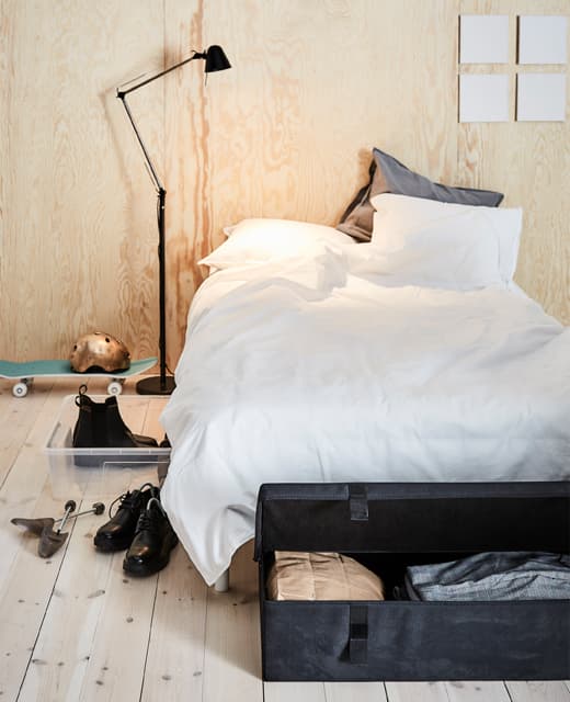 Two different under-bed storage boxes are shown next to the bed.
