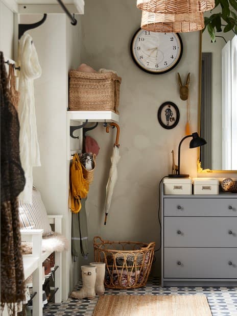 Two grey HAUGA chests with 3 drawers in a hallway with a LOHALS rug on the floor in front, and a mirror and a clock above.