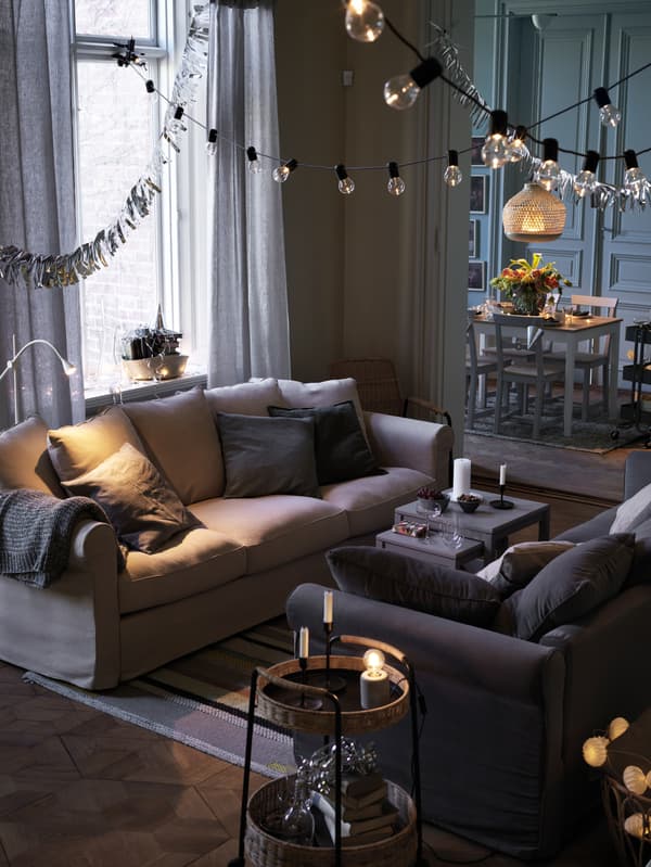 Two GRÖNLID sofa beds stand facing each other in a calm-looking living room, with a LUBBAN trolley beside one of them.
