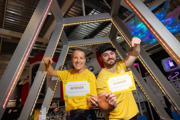 two IKEA co-workers holding golden tickets. 