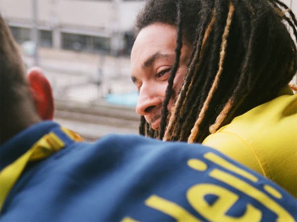 Two IKEA co-workers, one with dreadlocks, leaning forward and chatting.