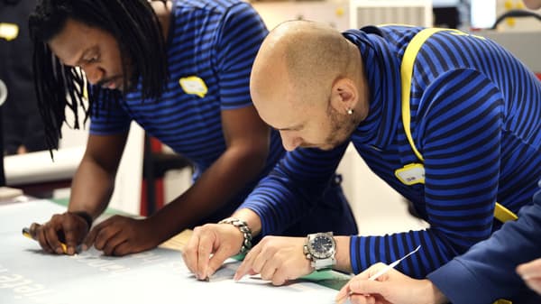 Two IKEA coworkers planning a design and drawing it on paper.