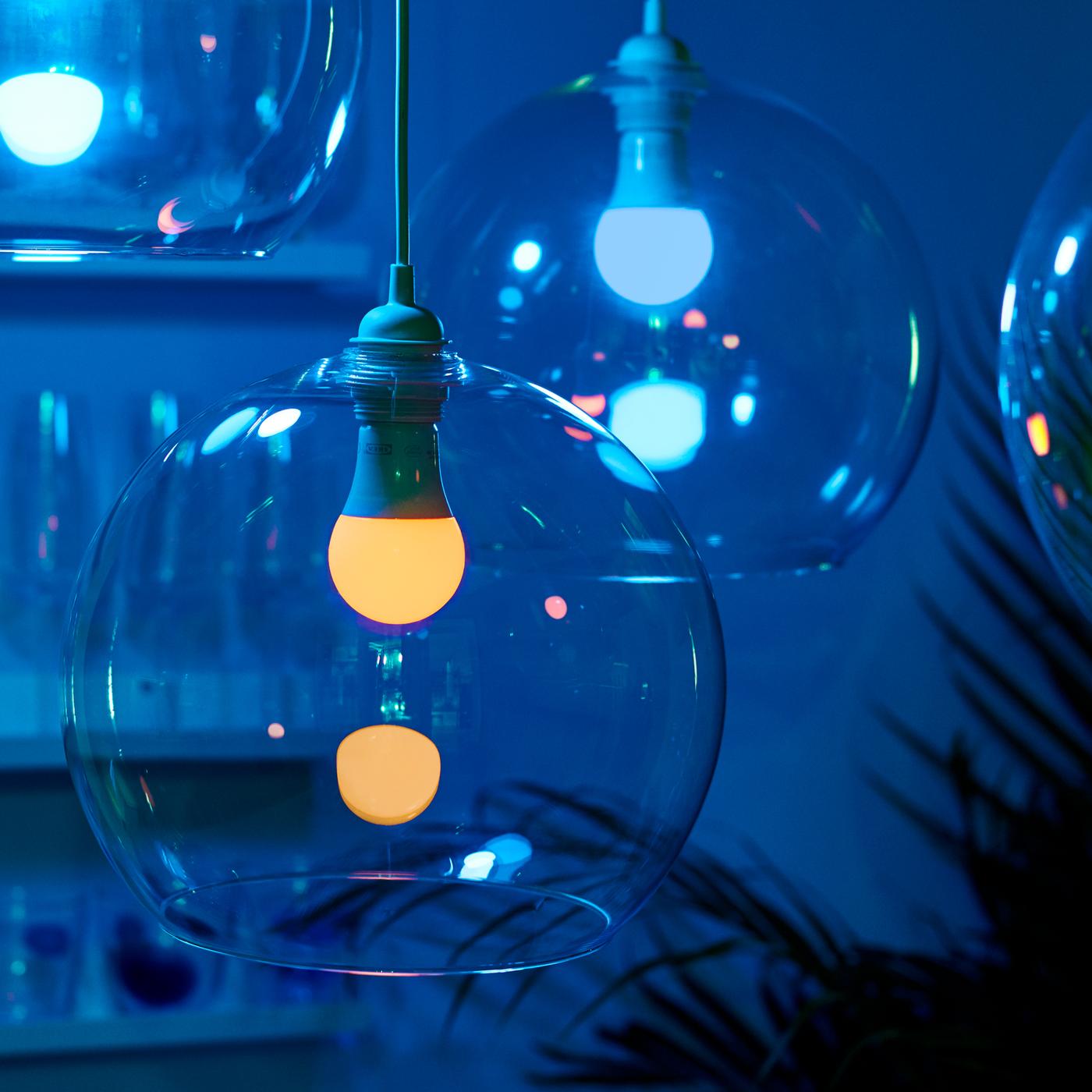 Two JAKOBSBYN pendant lamps containing TRÅDFRI dimmable bulbs that are switched to give off blue light.