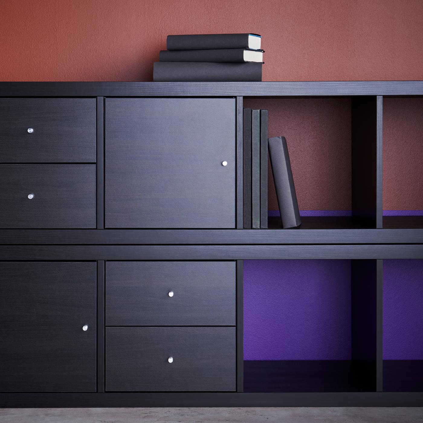 Two KALLAX shelving units fitted with KALLAX inserts with doors. Four books are on one shelf and three on top of the unit.