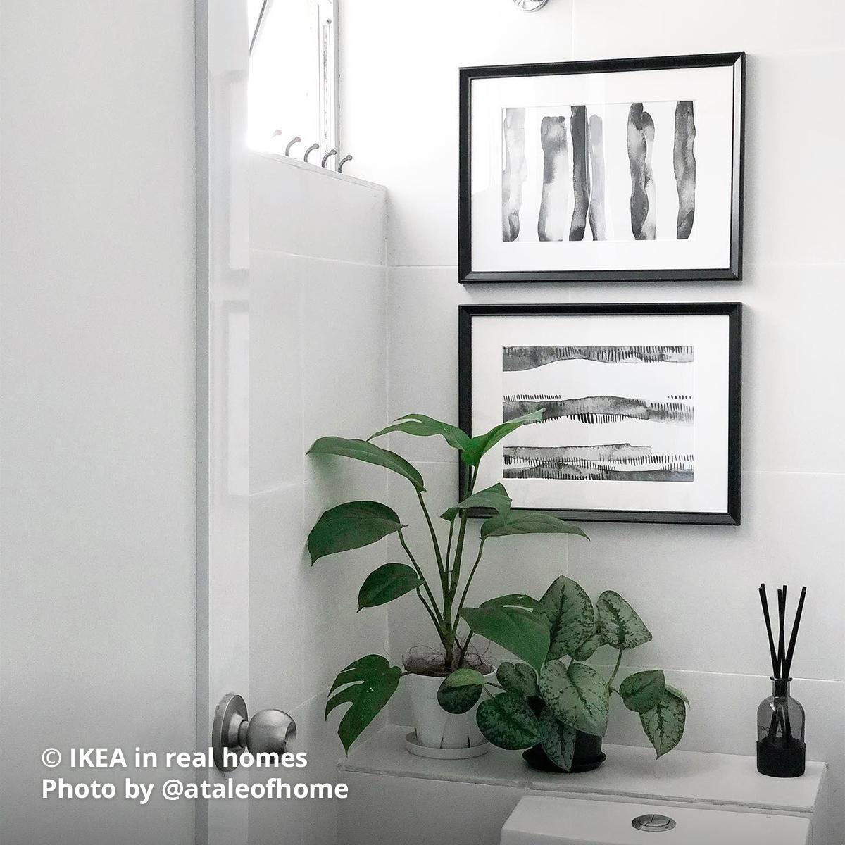 Two KNOPPÄNG black frame with abstract black & white painting is being framed and placed above WC wall with two potted plant and diffuser is being placed on the ledge. Photo by instagrammer @ataleofhome from IKEA in real homes ©
