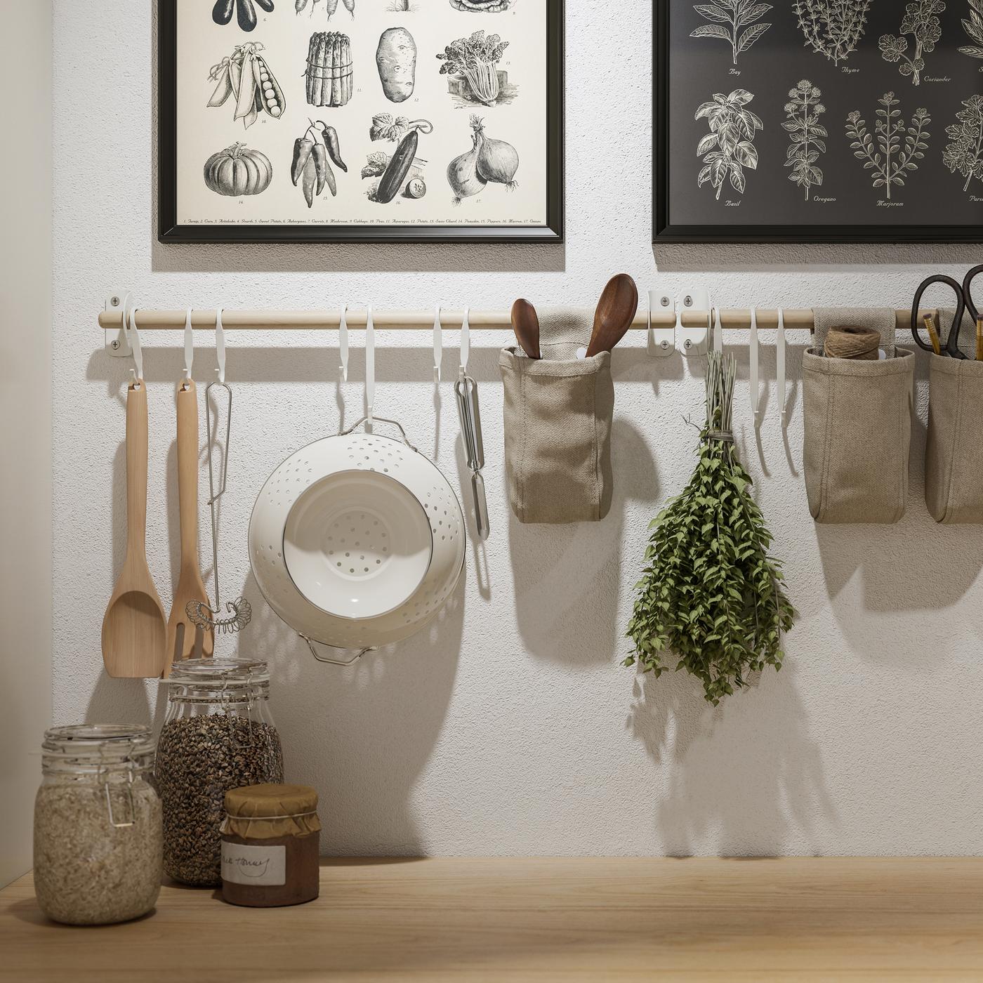 Two KNOPPÄNG frames with posters and NEREBY birch rails on a white wall, with hanging kitchen utensils and containers.