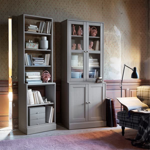 Two light green IKEA HAVSTA shelves, one with open storage and one with glass doors, made from solid pine wood.