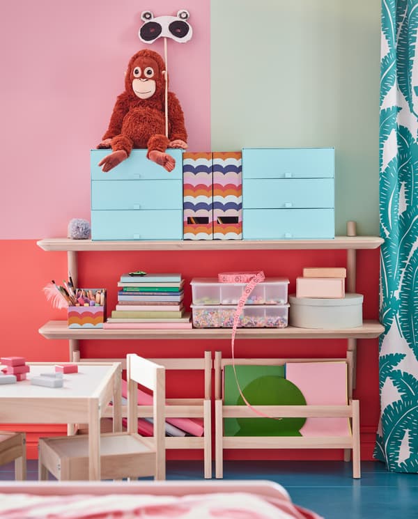 Two LISABO wall shelves in ash veneer – they store graphic, colourful storage boxes, a soft toy orangutan, books and crafts.