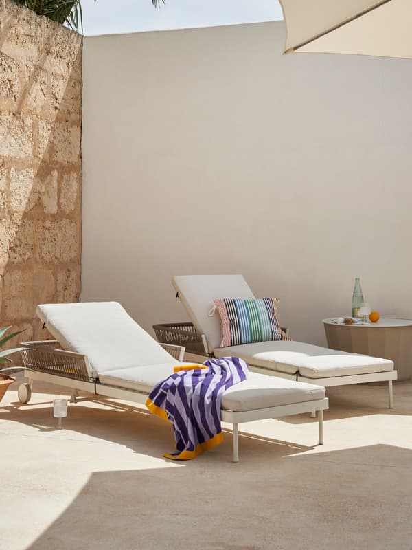 two lounge chairs outdoors in the run with textiles draped over