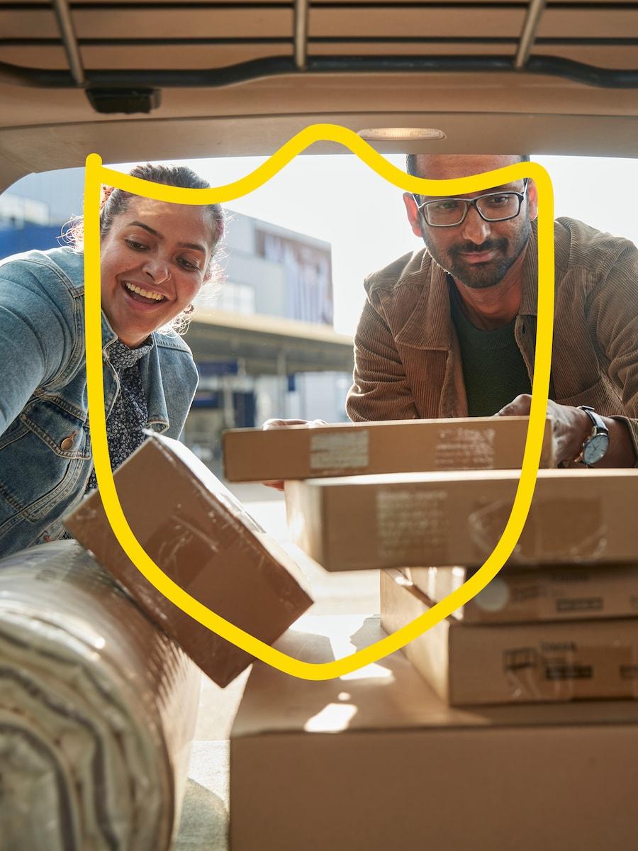 Two people are loading a car with flatpacks from IKEA.