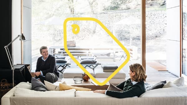 Two people are talking in a big living room.