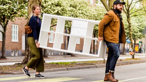 two people carrying KALLAX 