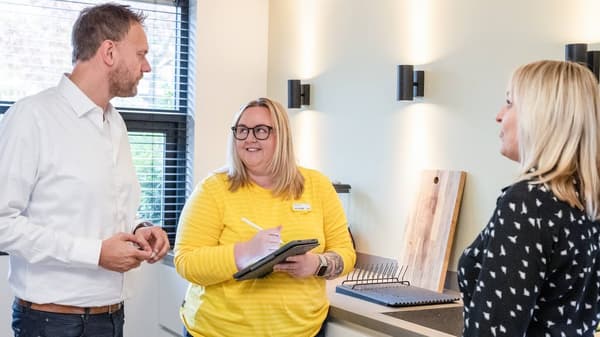 Two people chatting with an IKEA co-worker dressed in yellow.
