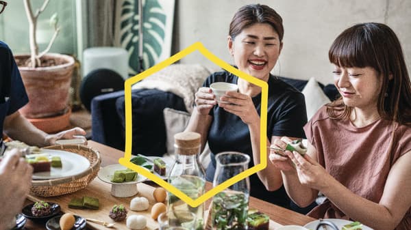 Two people having a meal with food and drinks on the table in front of them.