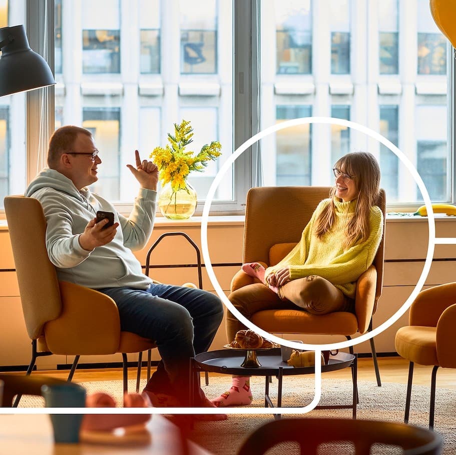 Two people in armchairs talking to each other