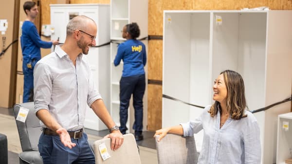 Two people in the as-is section at IKEA smiling at each other.