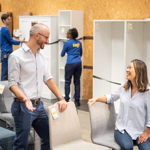 Two people looking to buy a chair from the second chance corner area of the store