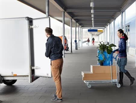 Two people picking up their IKEA items with a borrowed trailer.