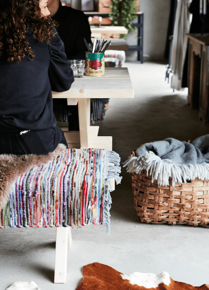 Two people sat on a table and bench next to a wicker basket