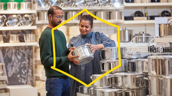 Two people shopping for pots in an IKEA store. A yellow frame in the shape of a hexagon on top of the image.