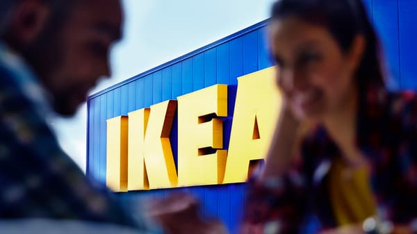 Two people silhouetted against the IKEA logo on an IKEA store.
