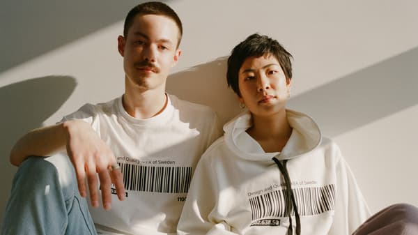 Two people wearing a t-shirt and hoodie from the EFTERTRÄDA limited collection