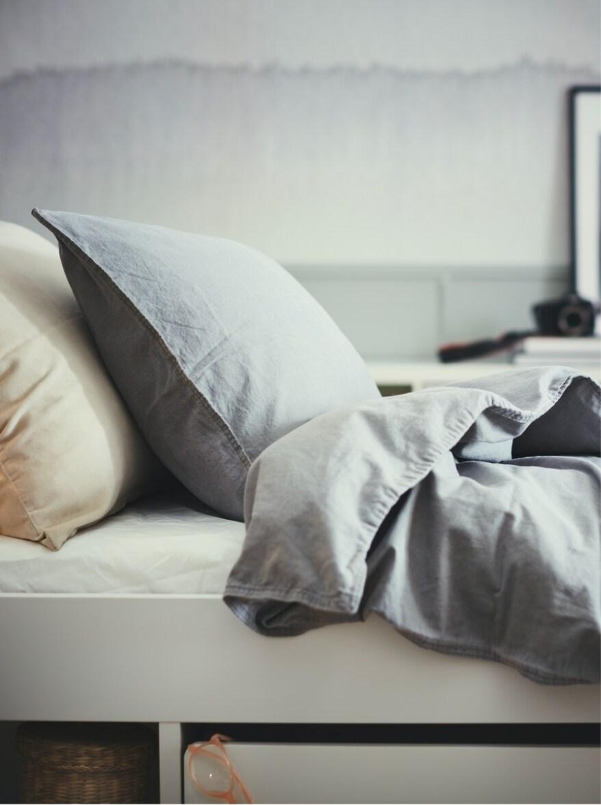 Two pillows and a blanket shown on a bed.