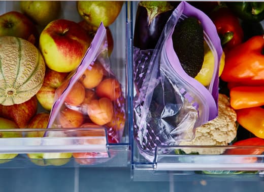 Two produce drawers are open and sorted by fruits and vegetables