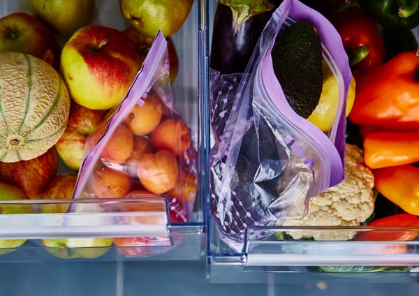 Two produce drawers are open and sorted by fruits and vegetables.