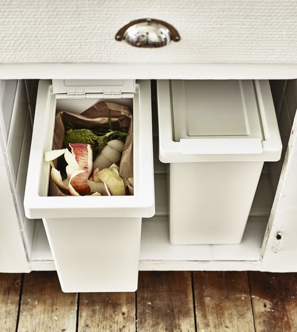 Two recycling boxes inside a kitchen cupboard.