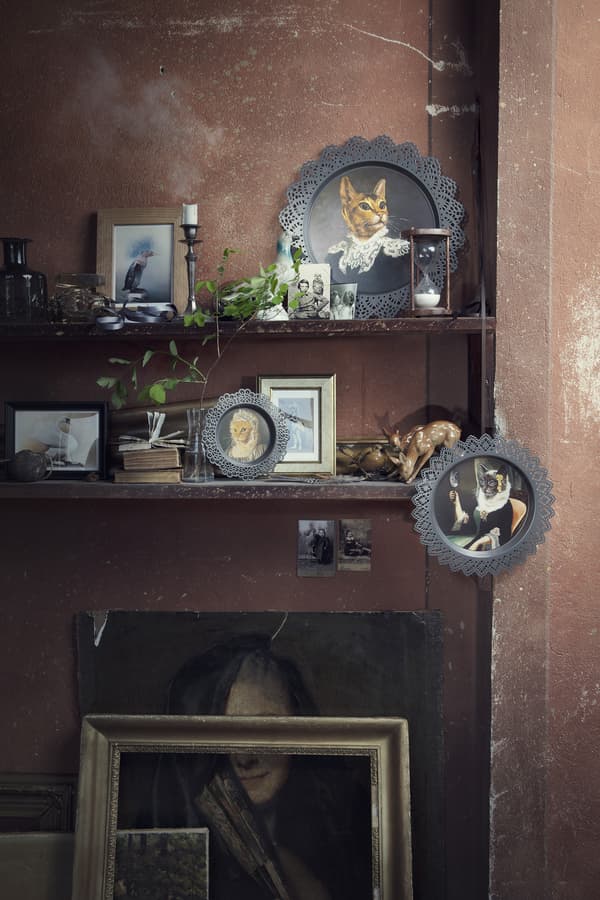 Two shelves with various ornaments and pictures, including SKURAR wall decoration