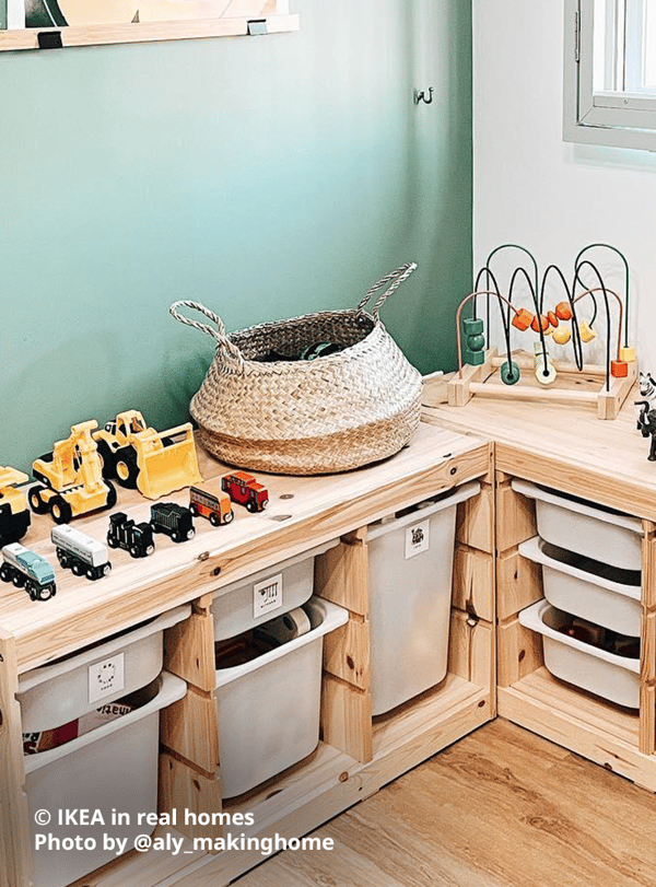 Two TROFAST light white stained pine toy storage combinations in a corner of the home below a window with grills. Several toy trucks and cars, rattan basket and other toys are lined up on top of the storage combinations, with white TROFAST storage boxes in various sizes in each slot with toys. Photo by instagrammer @aly_makinghome for IKEA in real homes.