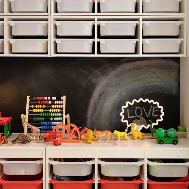 Two TROFAST storage combinations with boxes against a black wall. Four TROFAST wall storage with white boxes are above them.