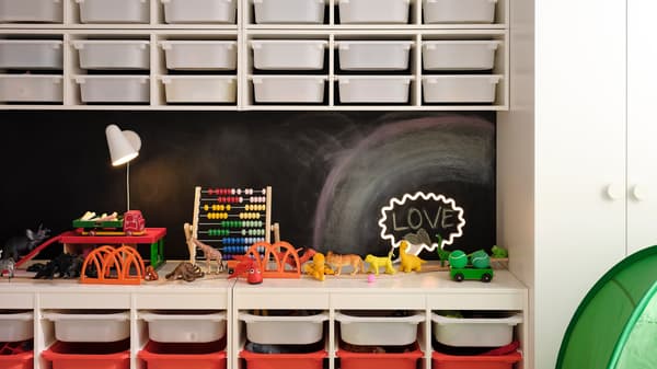 Two TROFAST storage combinations with boxes against a black wall. Four TROFAST wall storage with white boxes are above them.