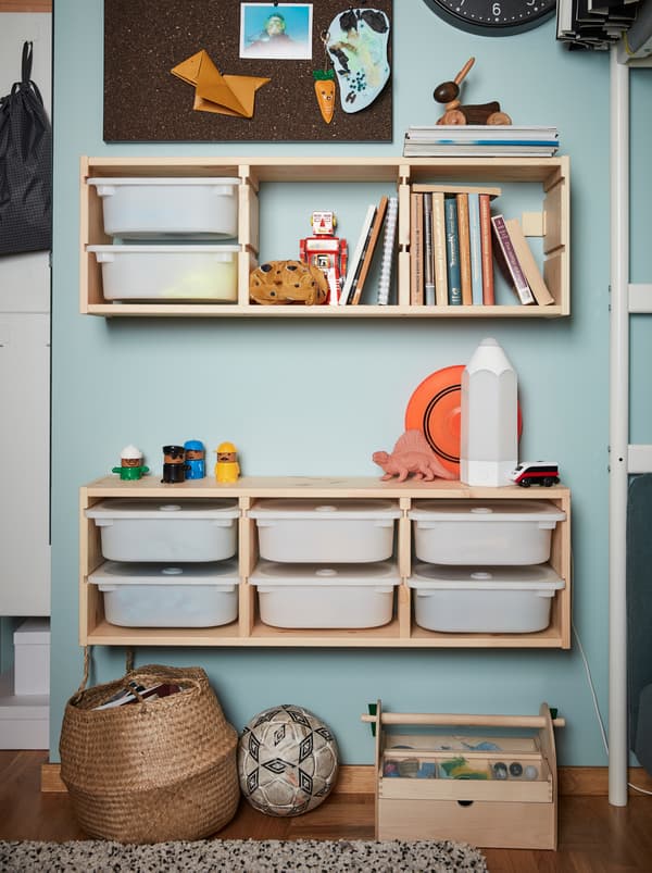Two units of wall storage from the children’s series TROFAST made from wooden frames and white plastic boxes.