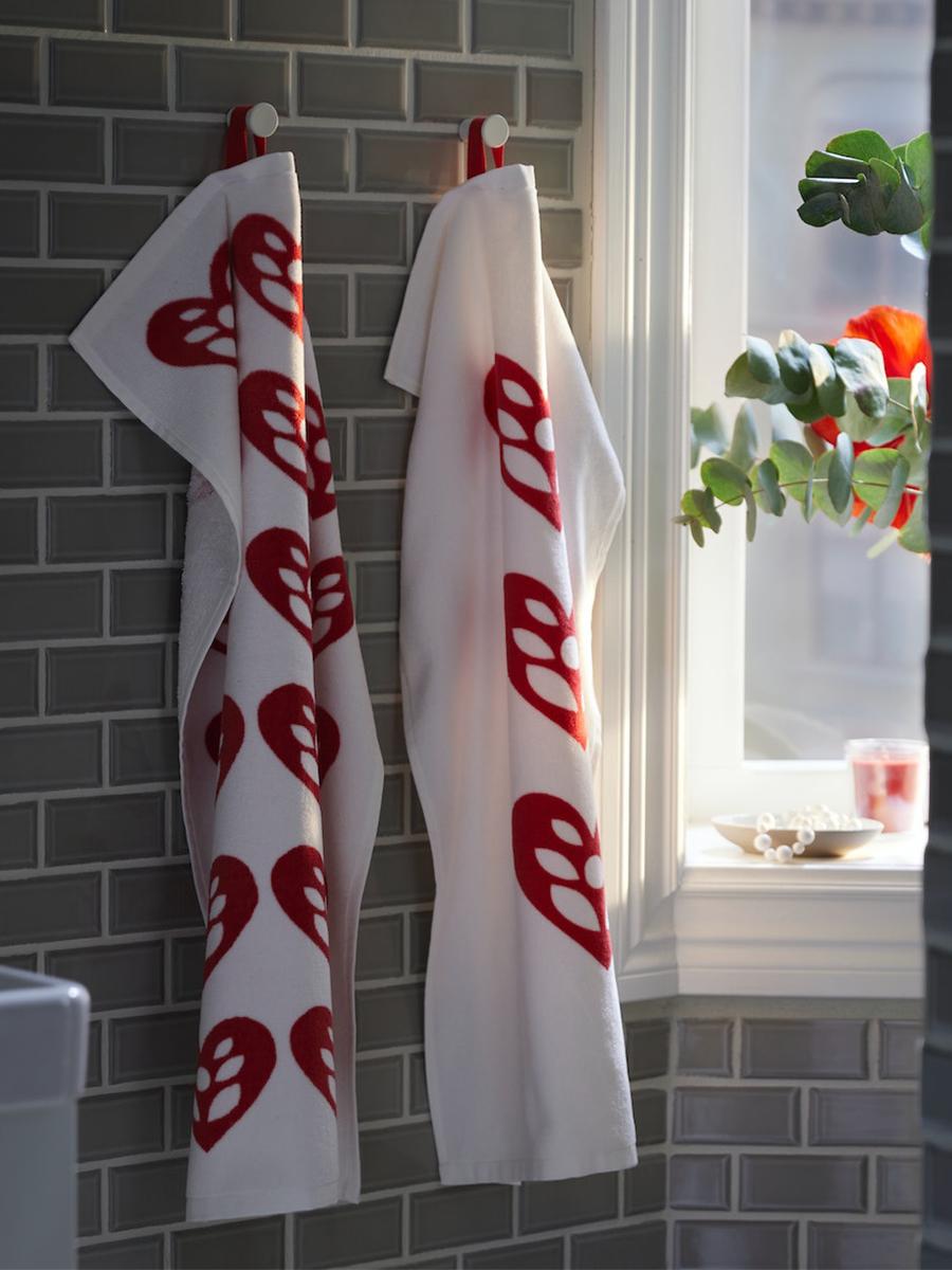 Two VINTERFINT 2022 hand towels are hung in the bathroom. The soft cotton towels feature heart patterns.