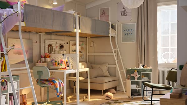 Two VITVAL loft beds and desk top are end-to-end along a beige wall with chairs in green and beige at the desks underneath.