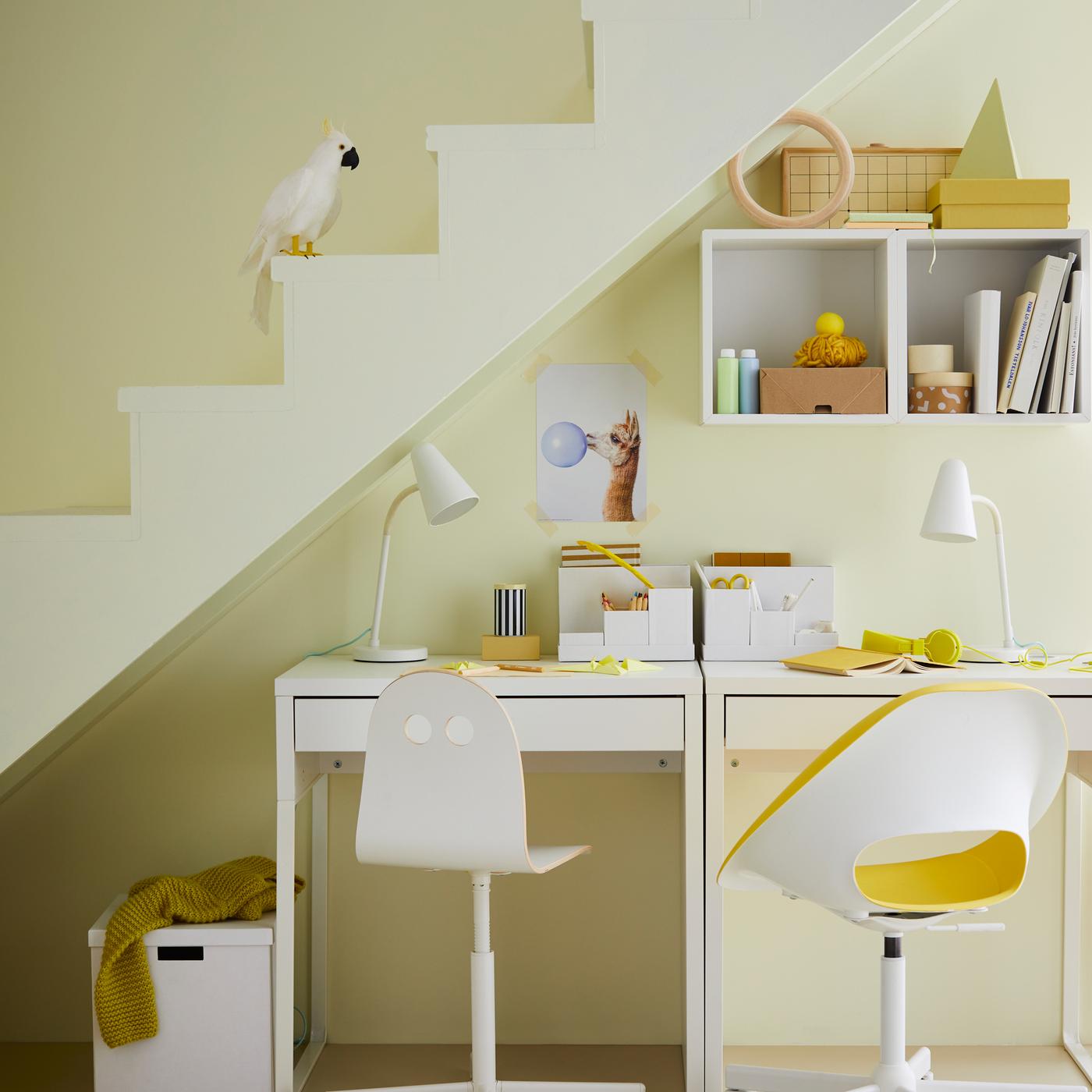 Two white desks with a VALFRED/SIBBEN children’s desk chair and ELDBERGET/MALSKÄR swivel chair are set under a stairwell.
