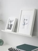 Two white frames on a white MOSSLANDA picture ledge.