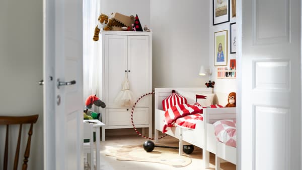 Two white SUNDVIK extendable beds stand end to end against a wall near a white SUNDVIK wardrobe in a bedroom.