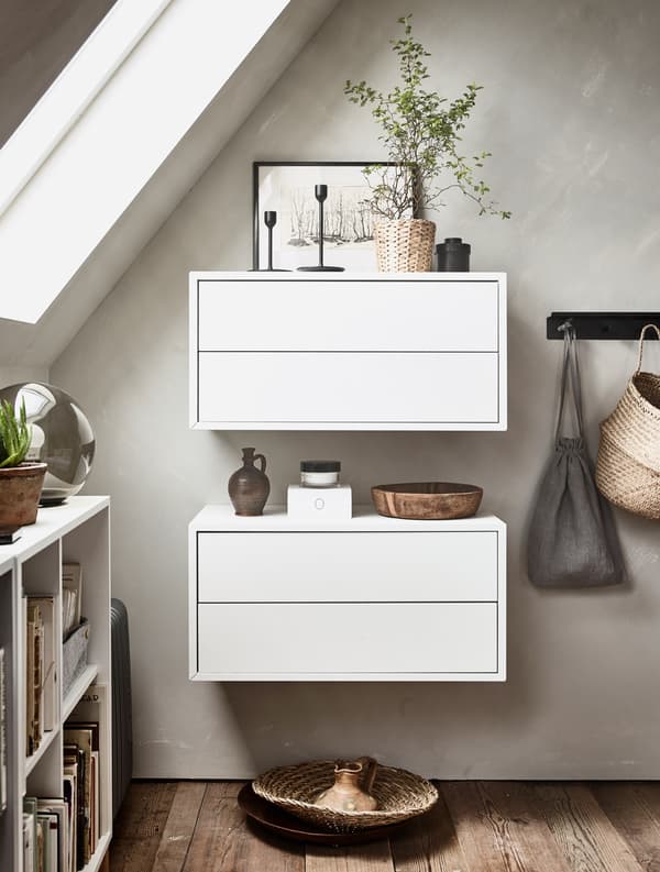 Two white wall cabinets hold small decorative items on top.