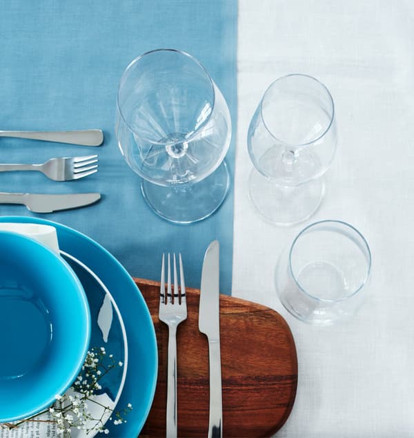 Two wine glasses and a water glass are arranged at a setting.