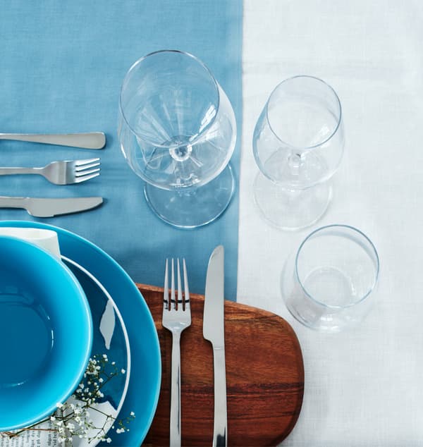 Two wine glasses and a water glass are arranged at a setting.