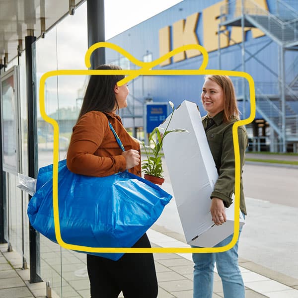 Two women chatting outside a department store.