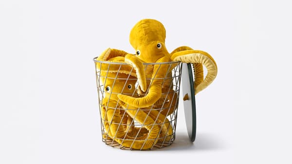 Two yellow BLAVINGAD octopus soft toy in a KVISTBRO storage table