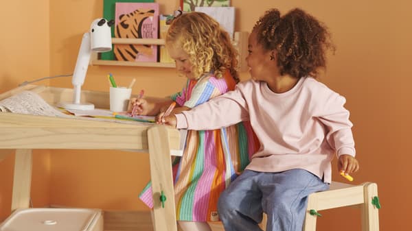 Two young children sitting at an art table 
