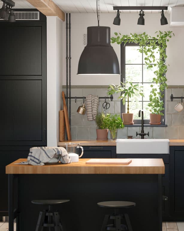 U- Förmige IKEA Küchenlösung mit Schwarzen Fronten einer hölzernen Arbeitsplattem weißem Waschbecken, schwarzem Wasserhahn und passenden schwarzen Bar-hockern.