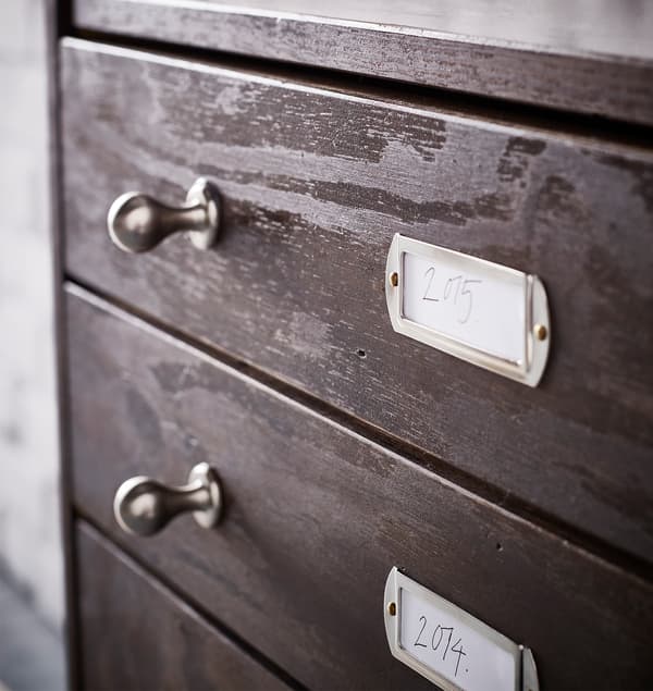 Új fém fogantyúk és címketartók egy IKEA RAST 3 fiókos szekrényen, mely sötétbarnára van festve. 