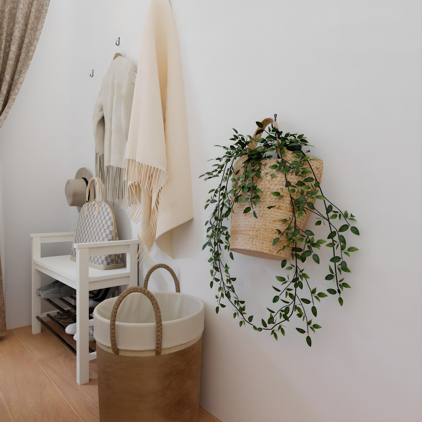 Ulazni prostor s bijelom klupom, košarom za rublje, visećim kaputima i torbom s biljkama.