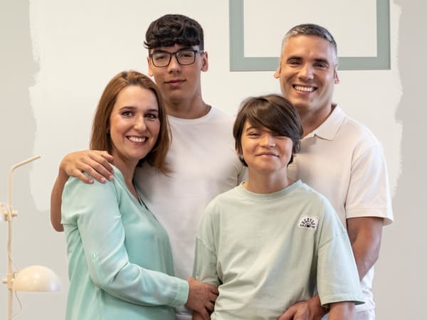 Uma família de quatro a sorrir para uma fotografia.